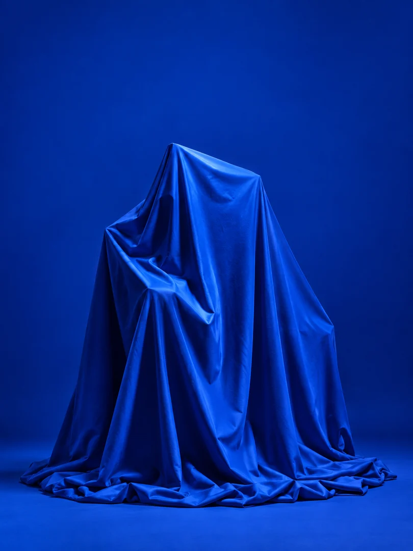 Blue fabric conceals a sculpture for the Gathering Gear reveal